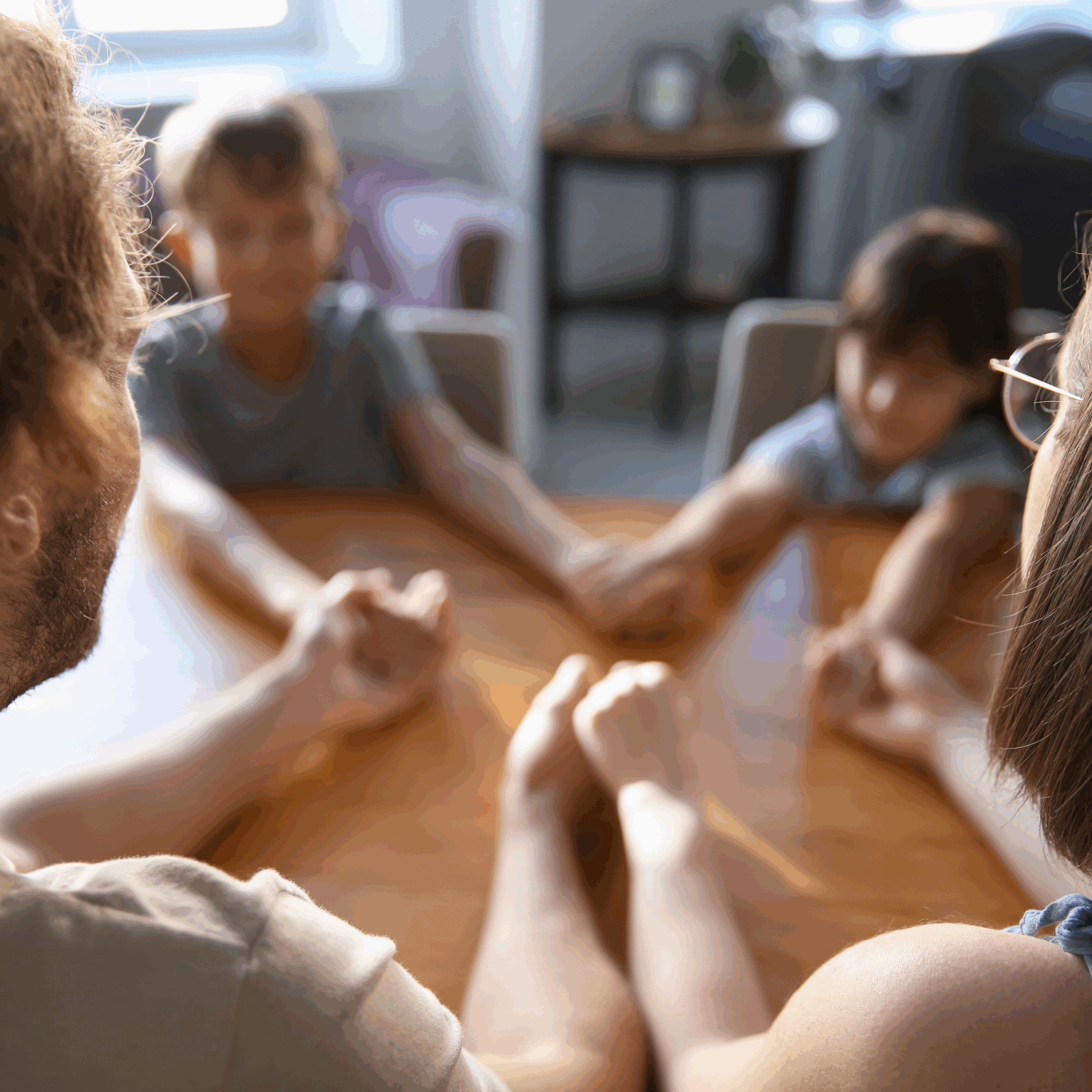 mom, dad, and two kids, holding hands, praying at a kitchen table